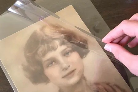 An old photo of a women contained in a plastic sleeve.