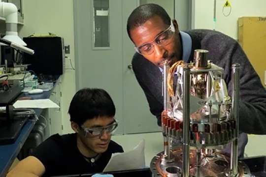A photo of Dr. Marvin Cummings and another person conducting an experiment.