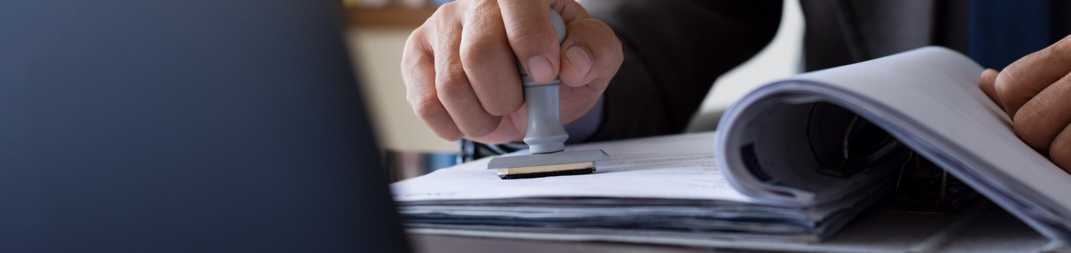 A close up of a person stamping a document.