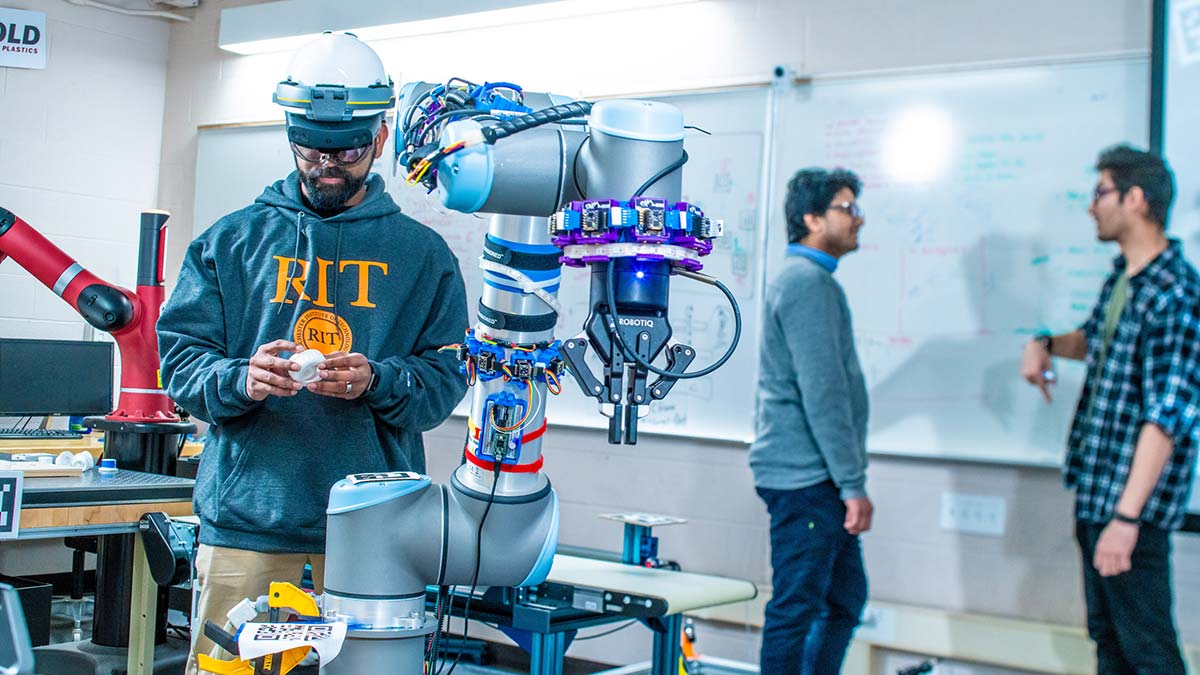 student wearing A R headset and working with a robotic arm in a lab setting.
