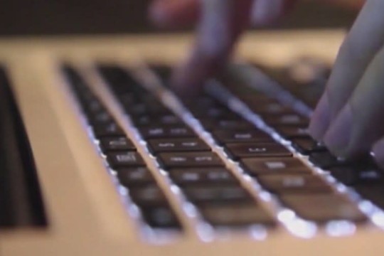 Hands typing on a laptop keyboard. 