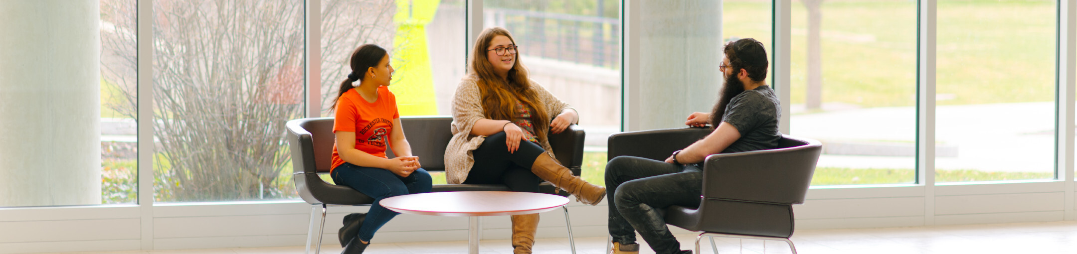 Three people sitting around a coffee table having a discussion