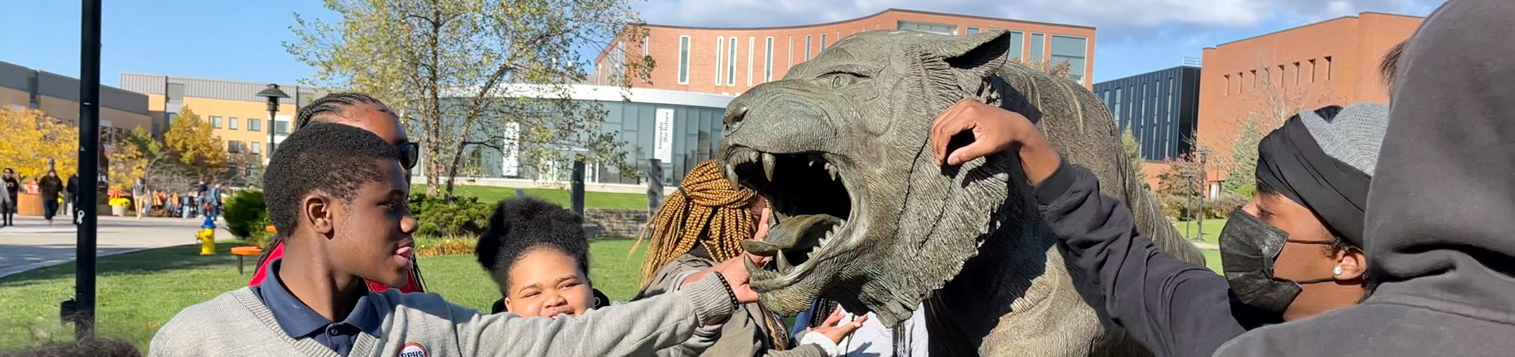 a group of students hanging out near the RIT tiger statue