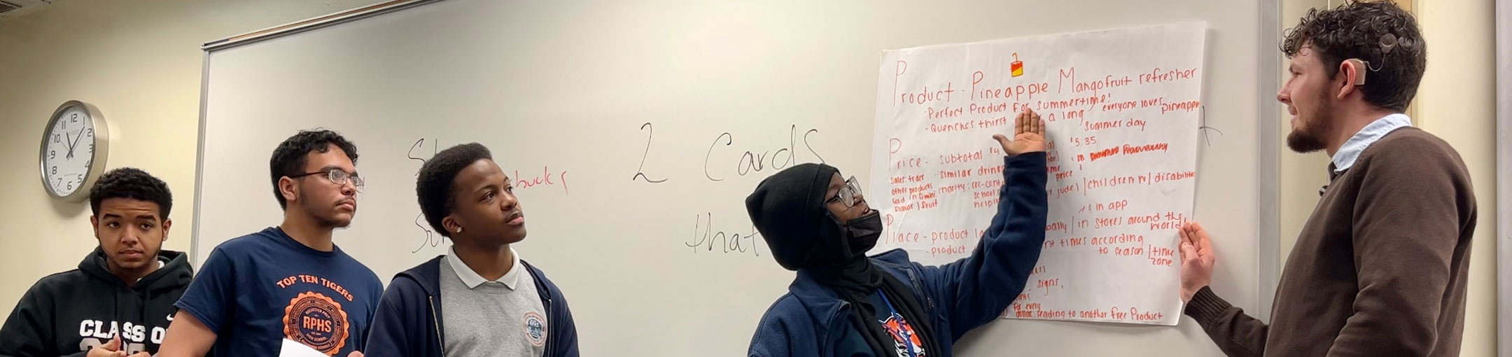 a professor and students working on a whiteboard
