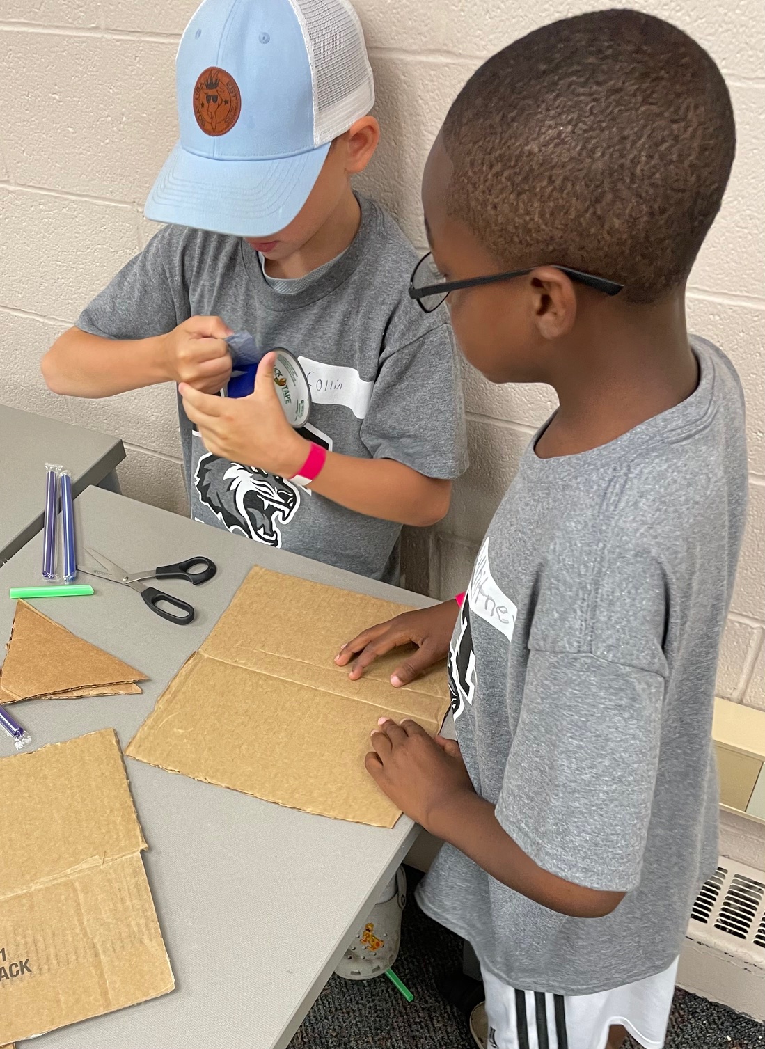 Two campers building structures with cardboard and supplies.