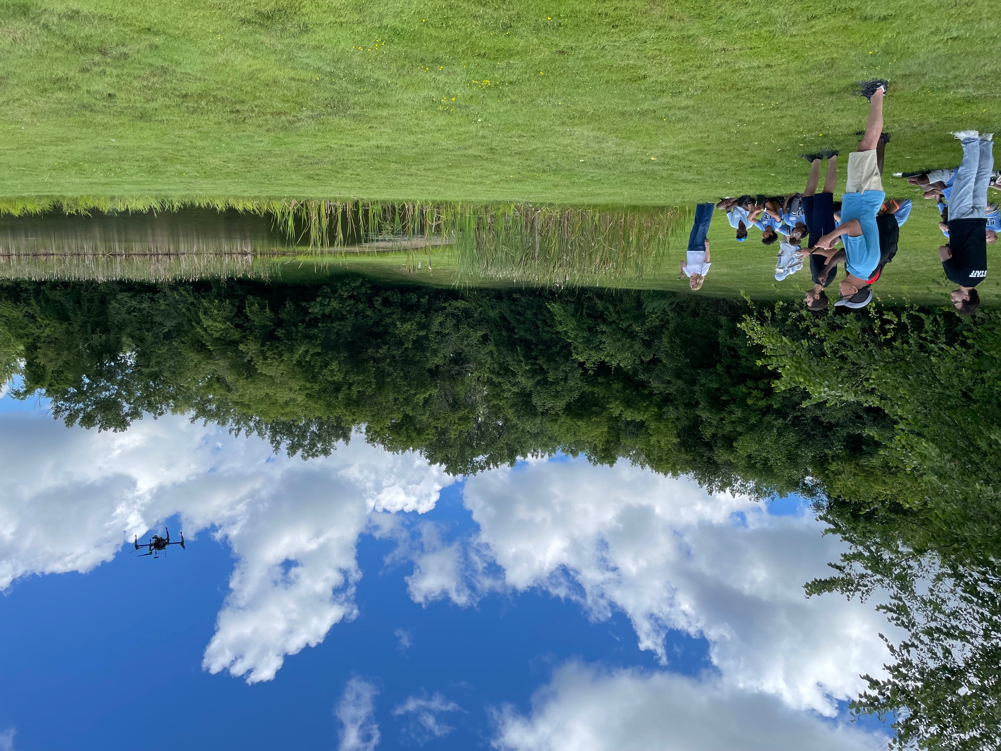 Campers and staff collecting data across a pond for a science project .