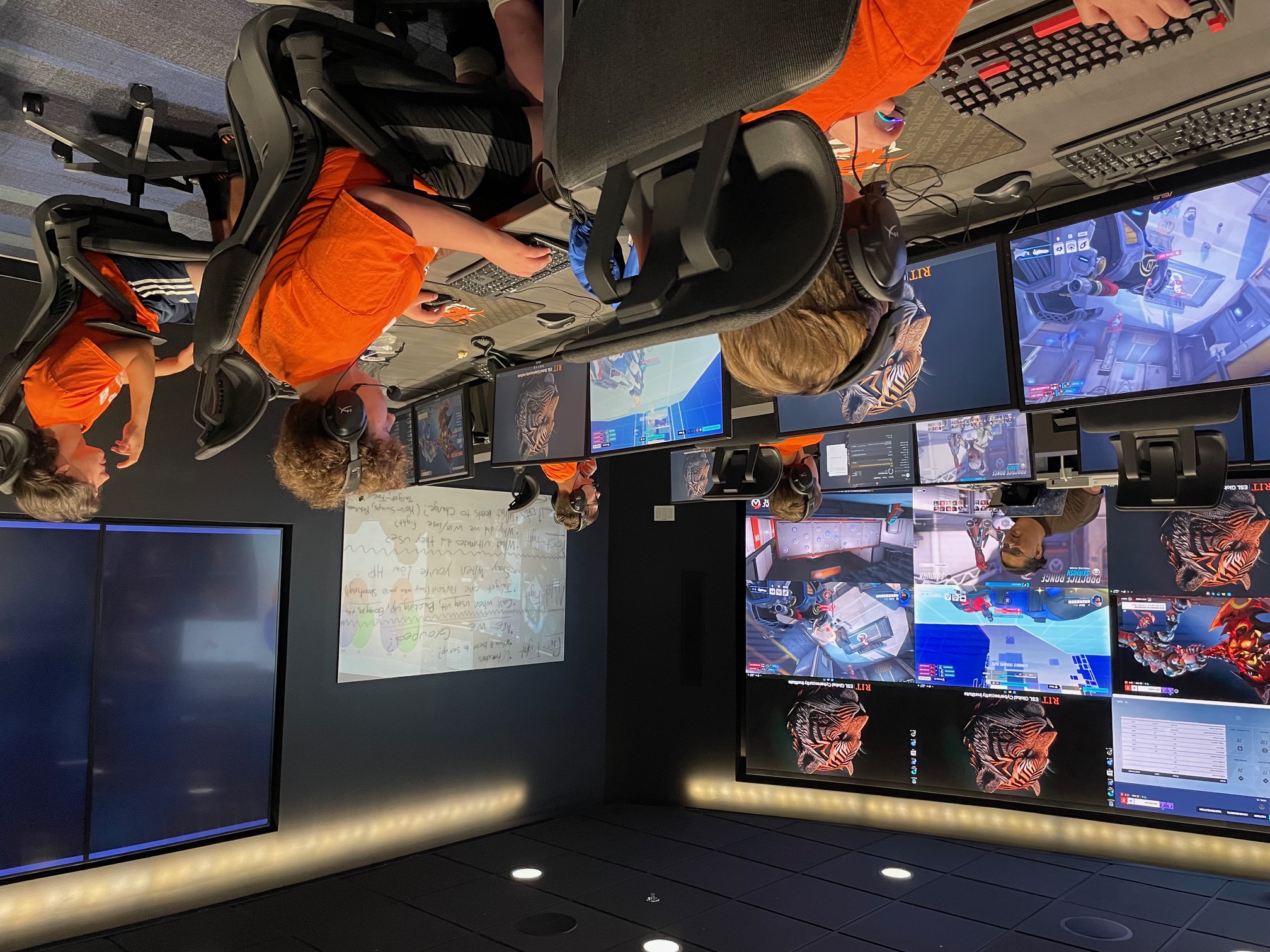 Youth with staff in the RIT Cyber Range learning about Esports strategies.