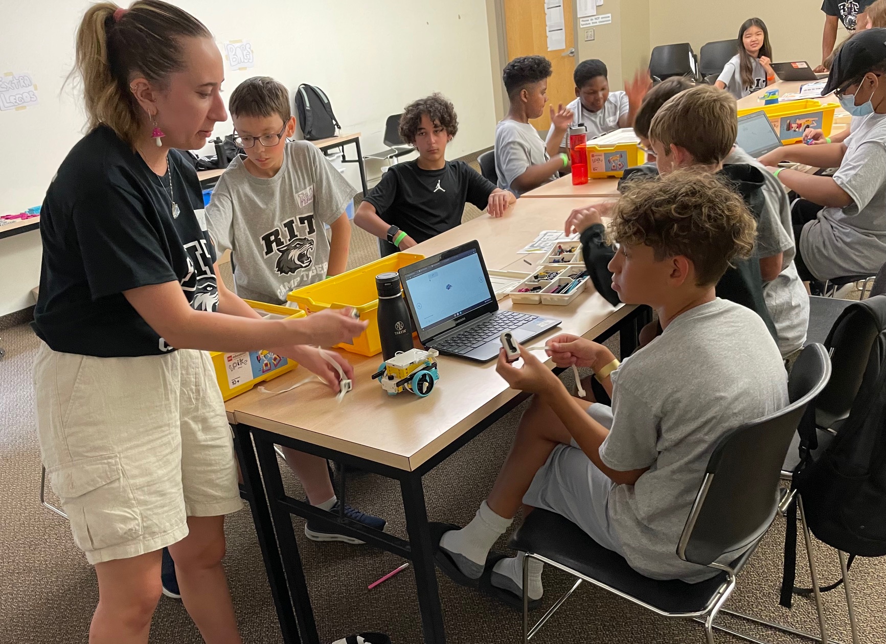 Youth working on Lego robotics project with camp staff.