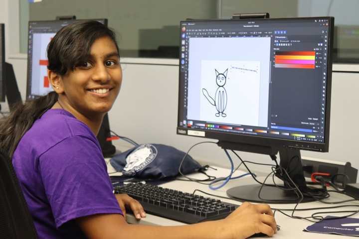 Girl at a computer creating a design for a project.