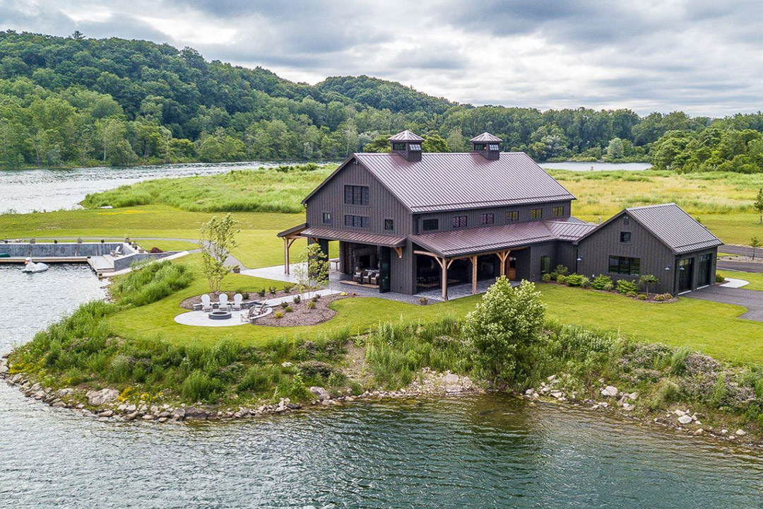 A beautiful cabin surrounded by water and green trees.