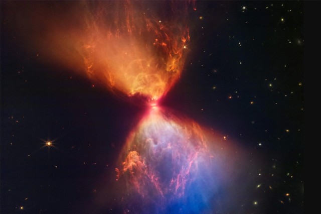 star forming in space, making an hourglass figure with a reddish top and reddish blue bottom.