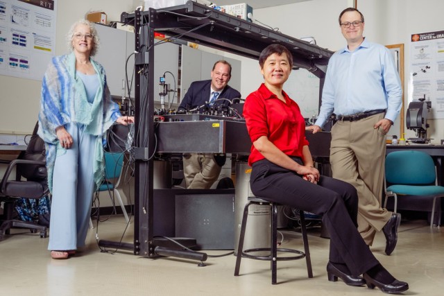 Research team poses with advanced photonics laboratory equipment at RIT.