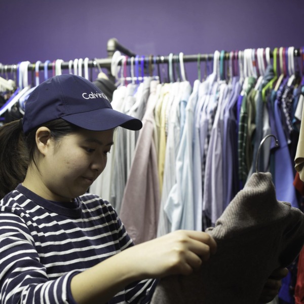 A member of the RIT community shopping through clothes at Bern's Closet