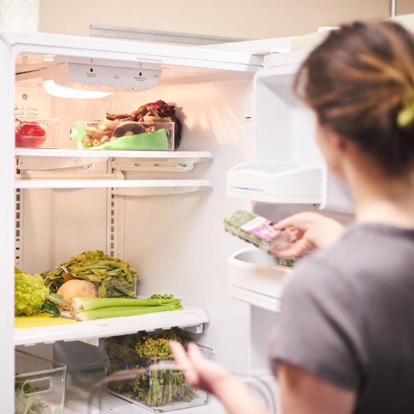 Someone restocking the refrigerator at FoodShare