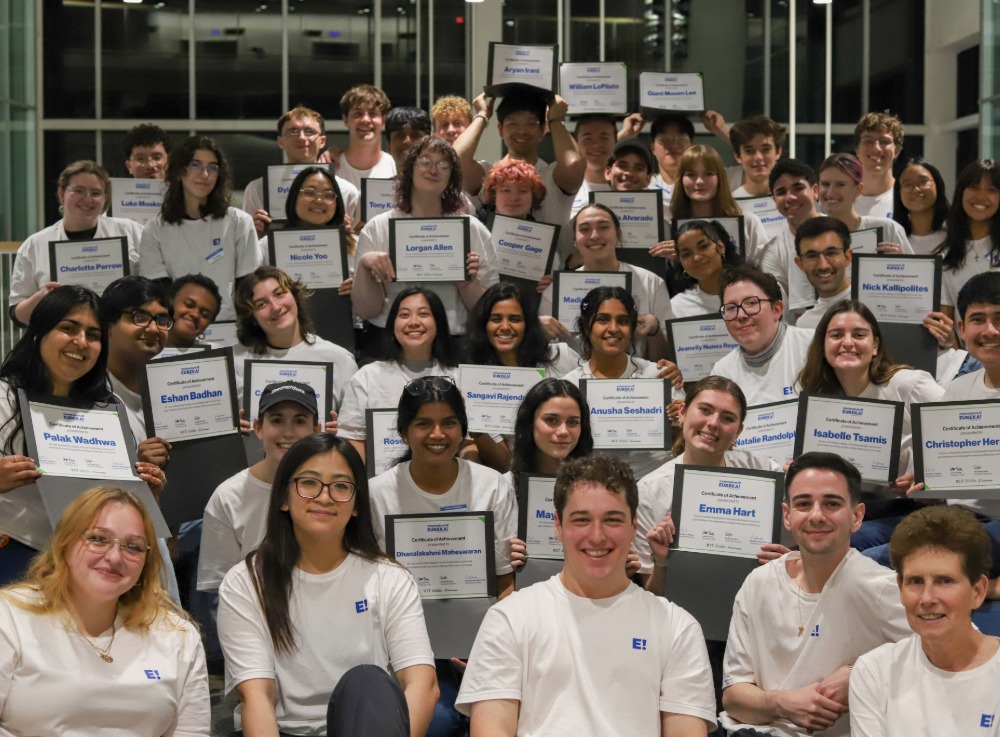 A group of students smile and pose for a photo with certifications of completion