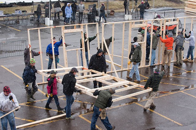 volunteers building framing for a house.