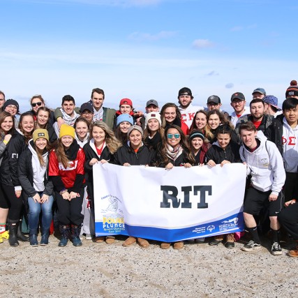team of students on beach of Lake Ontario in winter.