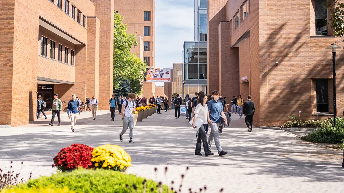 A view of the Quarter Mile walkway from the Infinity Quad, showing the College of Liberal Arts on the left and the Library on the right.