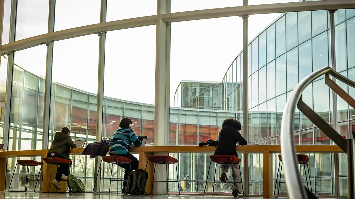 Students sitting at a table in the SHED atrium.
