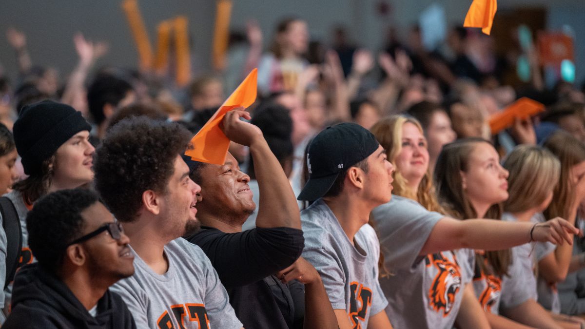 students during orientation throwing paper airplanes