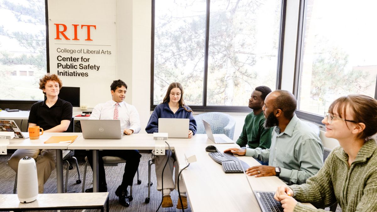 a group of student and faculty researchers engaged in a discussion