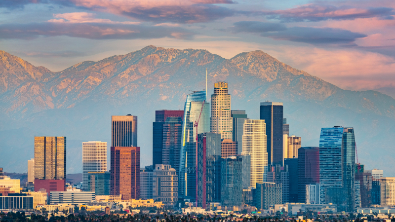 the LA skyline at dusk with mountains in far distance