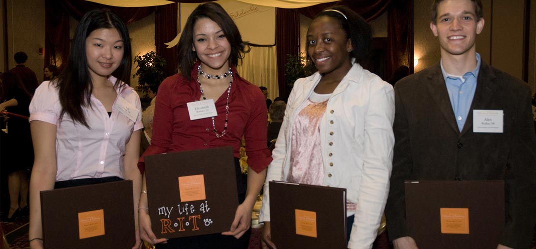 Students dressed up, holding awards