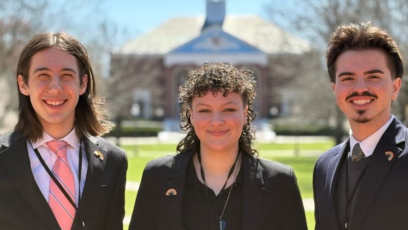 three students outdoors at an historical site 
