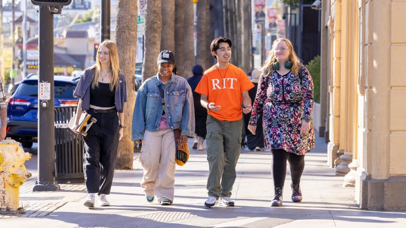 four students walking down a street in LA