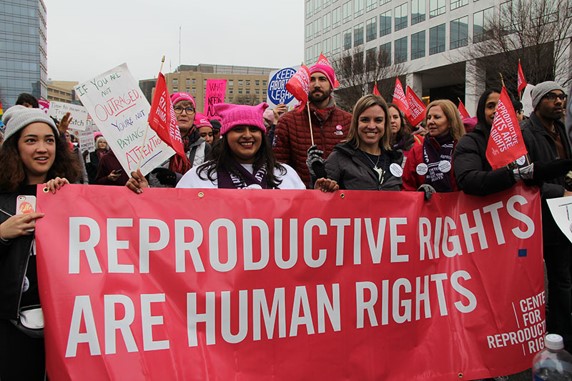Protesters holding a sign that reads Reproductive rights are human rights.
