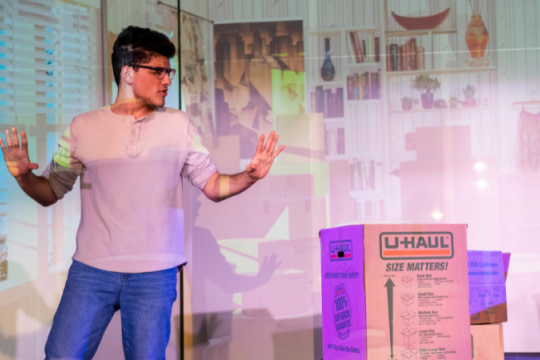 a photo of a male student speaking in front of a large group