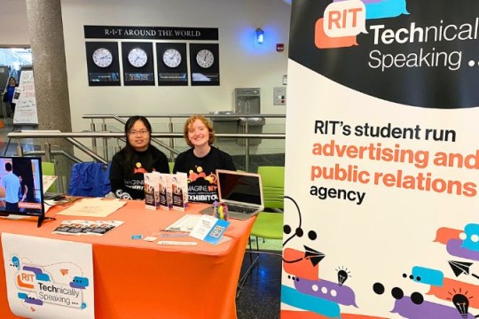 two students at a table during imagine RIT representing Technically Speaking