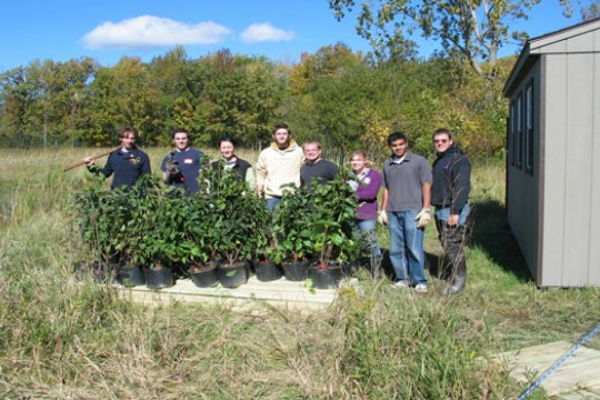 People posing for camera near plants