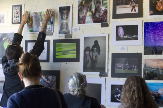 People hanging art on wall