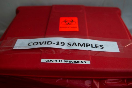 red medical bin labeled "COVID-19 samples"