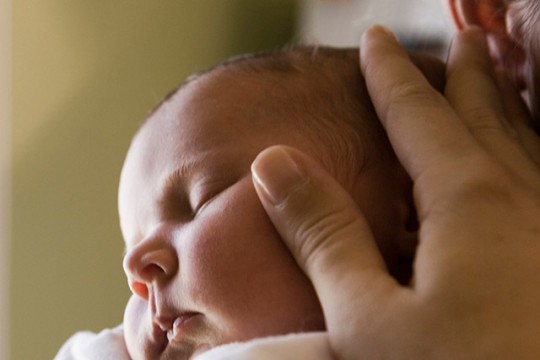 baby sleeping on mother's shoulder.