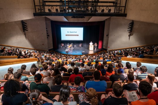view from the top of a crowded auditorium looking down at the stage.