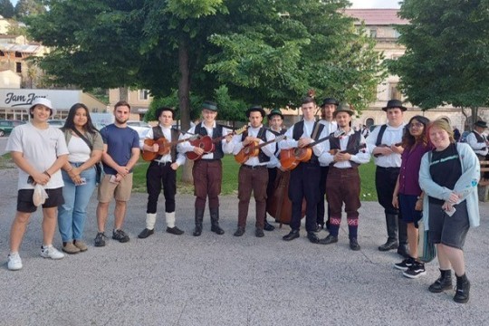 college students standing next to traditional Croatian folklore musicians.
