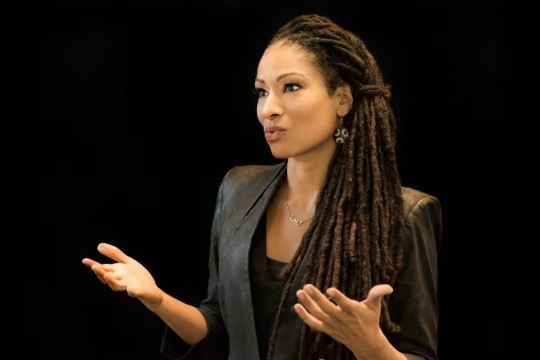 a close up photo of Ruha Benjamin speaking on a stage.