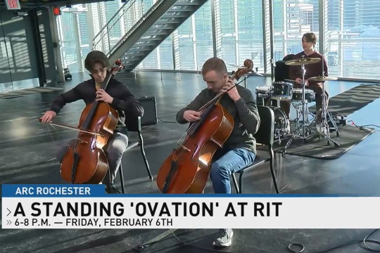 two students playing Cello's appear behind a chyron for 13 W H A M Television.