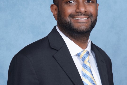 Studio portrait of a person in a suit wearing a tie