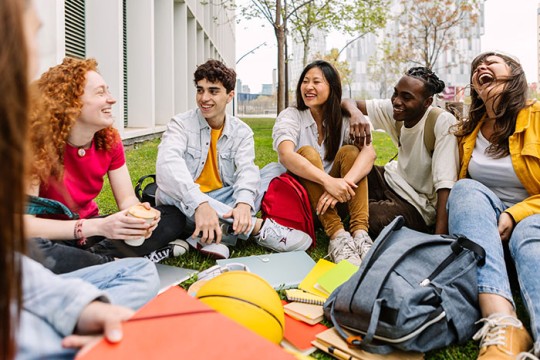 students sitting outside in a college setting.