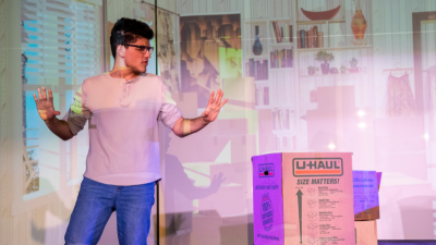 a photo of a male student speaking in front of a large group