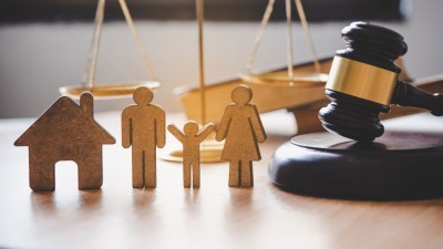 wooden cutout figures of a family with scales of justice and judges gavel