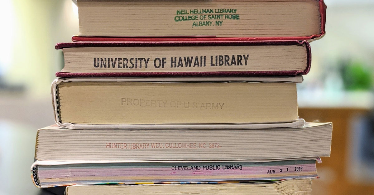 A stack of books from various libraries across the country