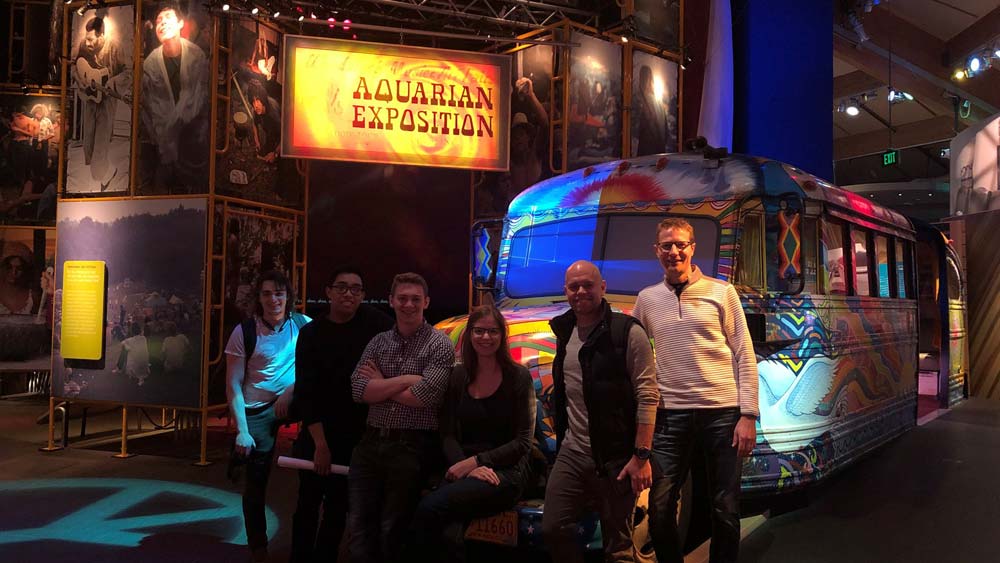 A group of people standing in front of a van painted with bright colors