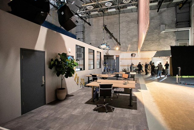 Stage set with scenery: wall with door and windows, tables and chairs