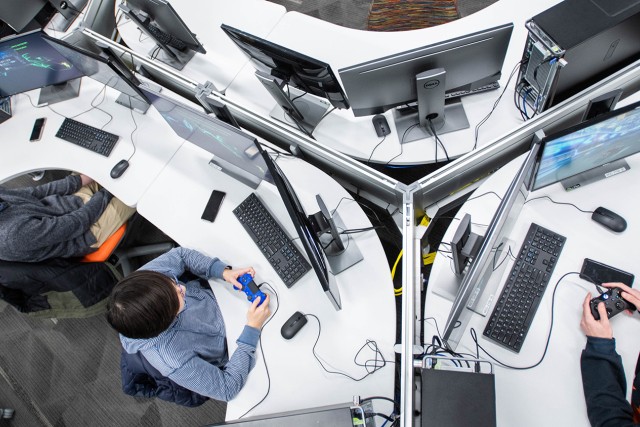 Overhead view of students on desiktop computers with gaming controllers
