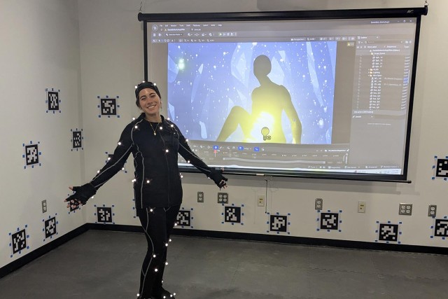 student wearing a suit with sensors in a room that captures movements.