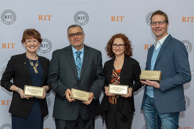 four people holding Golden Brick awards.